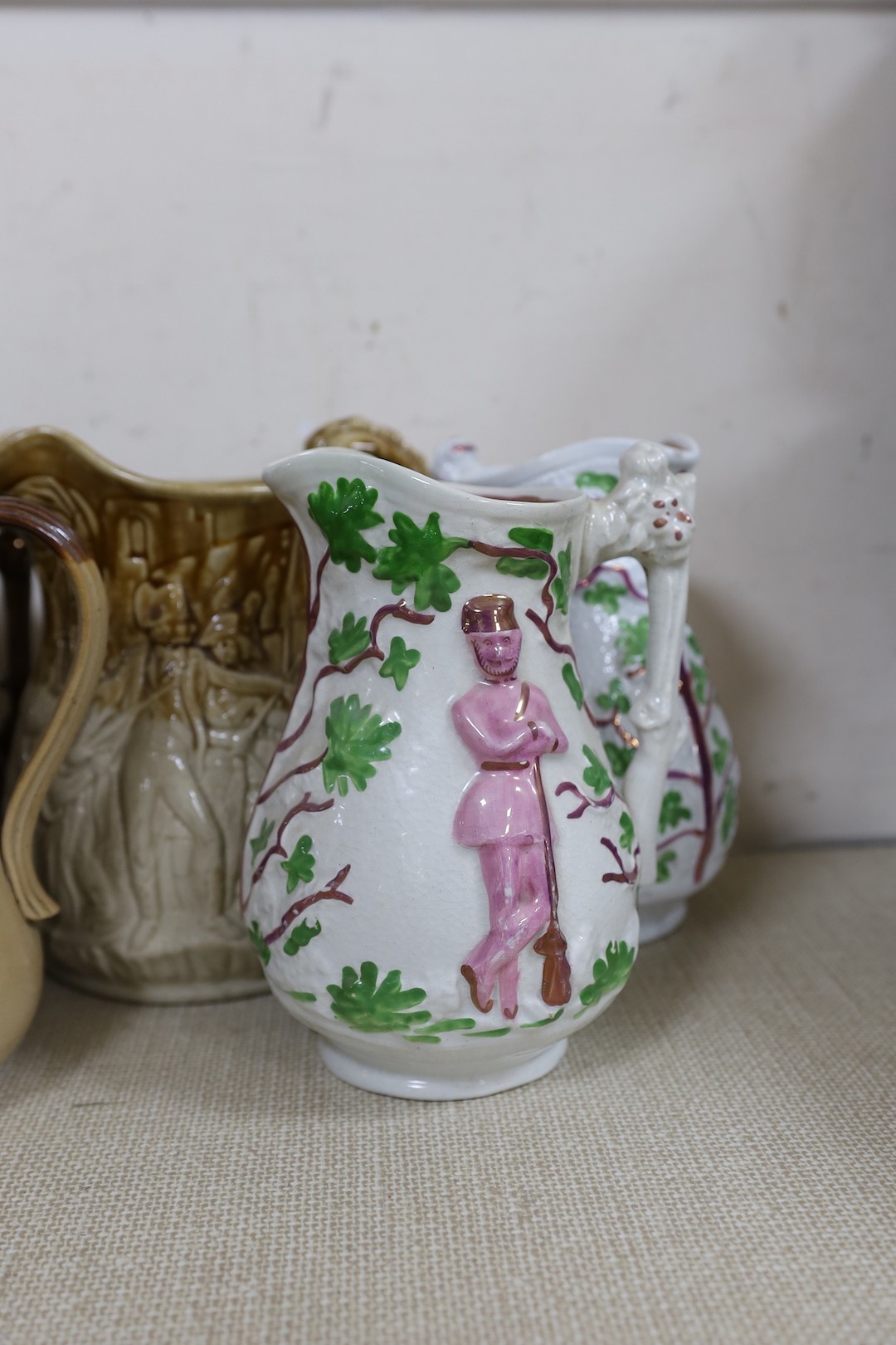 A Doulton Lambeth South Africa 1900 commemorative jug, 21cm, two relief moulded Volunteer jugs and four other jugs